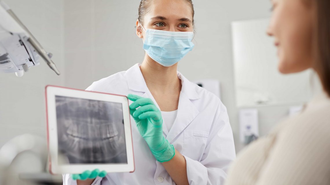 Doutora segunrando tablet com Raio-X para paciente - Orthoclin