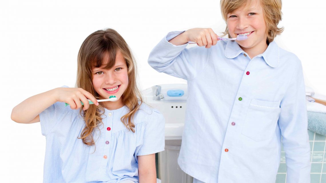 Crianças sorrindo enquanto escovam os dentes - Orthoclin