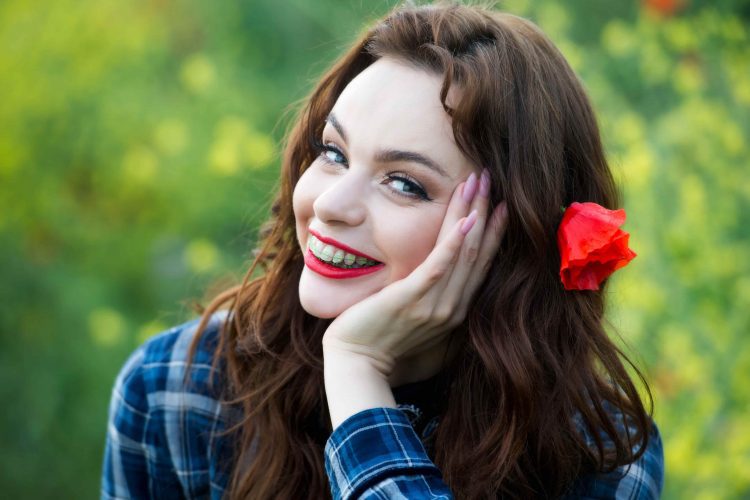 Mulher sorrindo e com aparelho metálico - Orthoclin