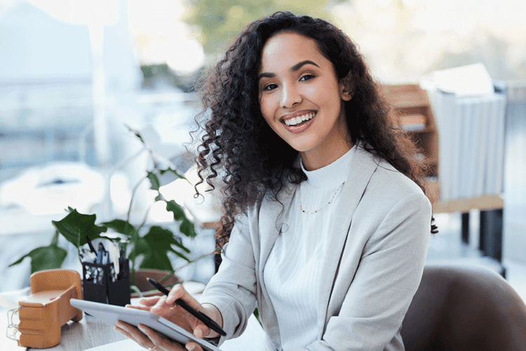 Profissional sorrindo no trabalho, refletindo a importância do sorriso no trabalho para a construção de boas relações e imagem positiva.