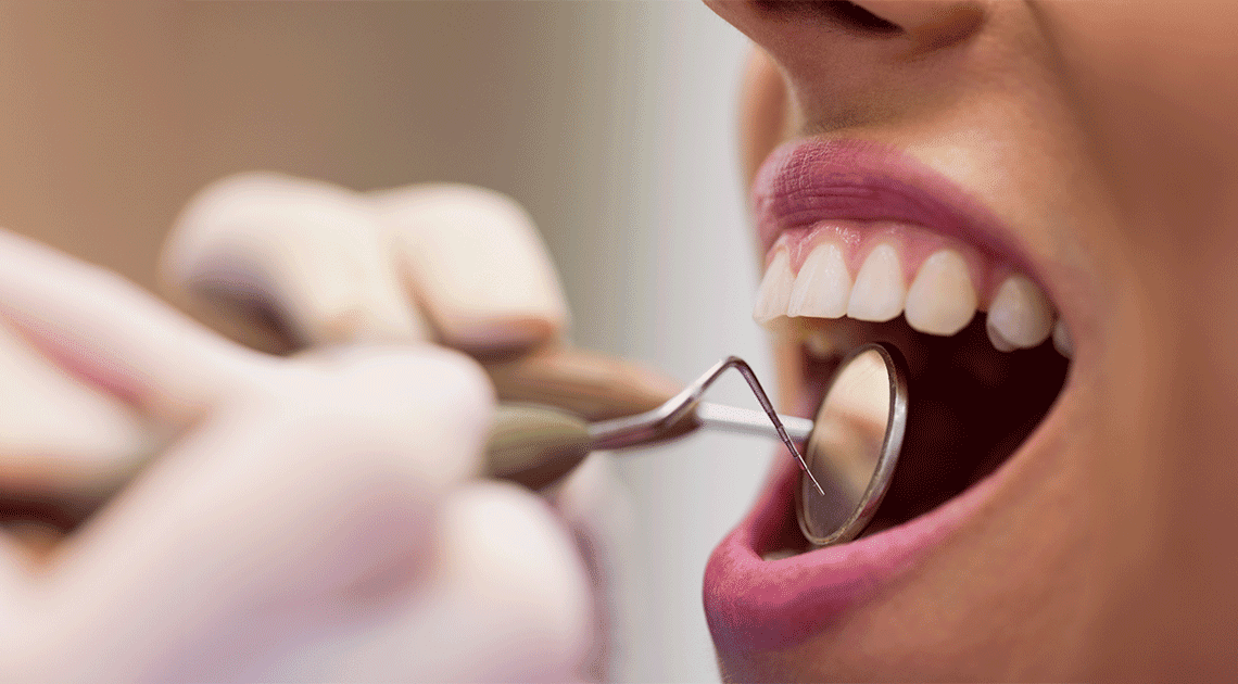 Dentista realizando exame em paciente para avaliar a saúde da gengiva e prevenir problemas bucais.