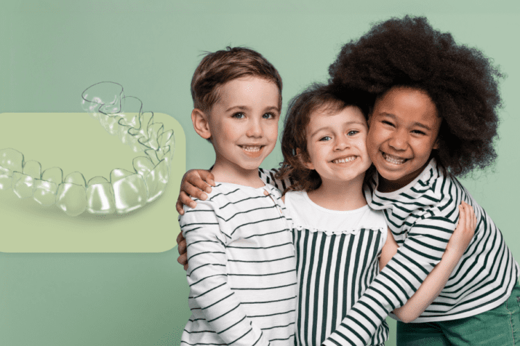 Crianças sorrindo ao lado de um modelo de alinhador, destacando os aparelhos ortodônticos usados na infância.