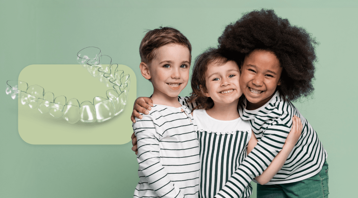 Crianças sorrindo ao lado de um modelo de alinhador, destacando os aparelhos ortodônticos usados na infância.